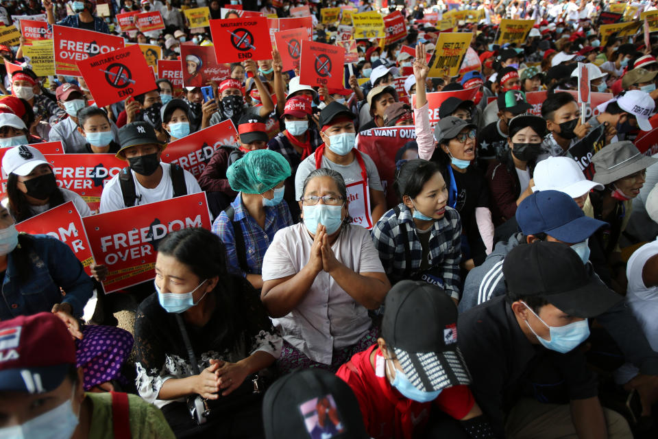 Anti-coup protesters gather outside the Hledan Centre in Yangon, Myanmar Friday, Feb. 19, 2021. The daily protests campaigning for civil disobedience in Myanmar are increasingly focusing on businesses and government institutions that sustain the economy. (AP Photo)