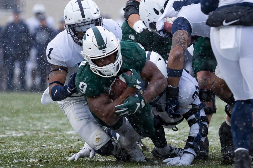 Nov 27, 2021; East Lansing, Michigan, USA; Michigan State Spartans running back Kenneth Walker III (9) runs for a touchdown against Penn State Nittany Lions safety Jaquan Brisker (1) and defensive tackle Dvon Ellies (91) during the first quarter at Spartan Stadium. Mandatory Credit: Raj Mehta-USA TODAY Sports