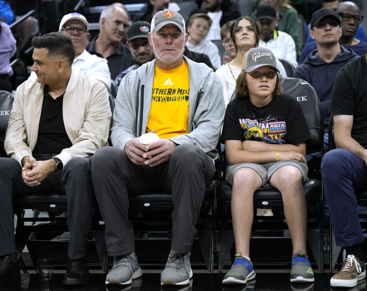 Brett Favre (middle), sitting courtside at a Bucks-Kings game in Sacramento in March, is a prominent figure in a Mississippi investigation of misspent welfare funds. (Photo by Thearon W. Henderson/Getty Images)