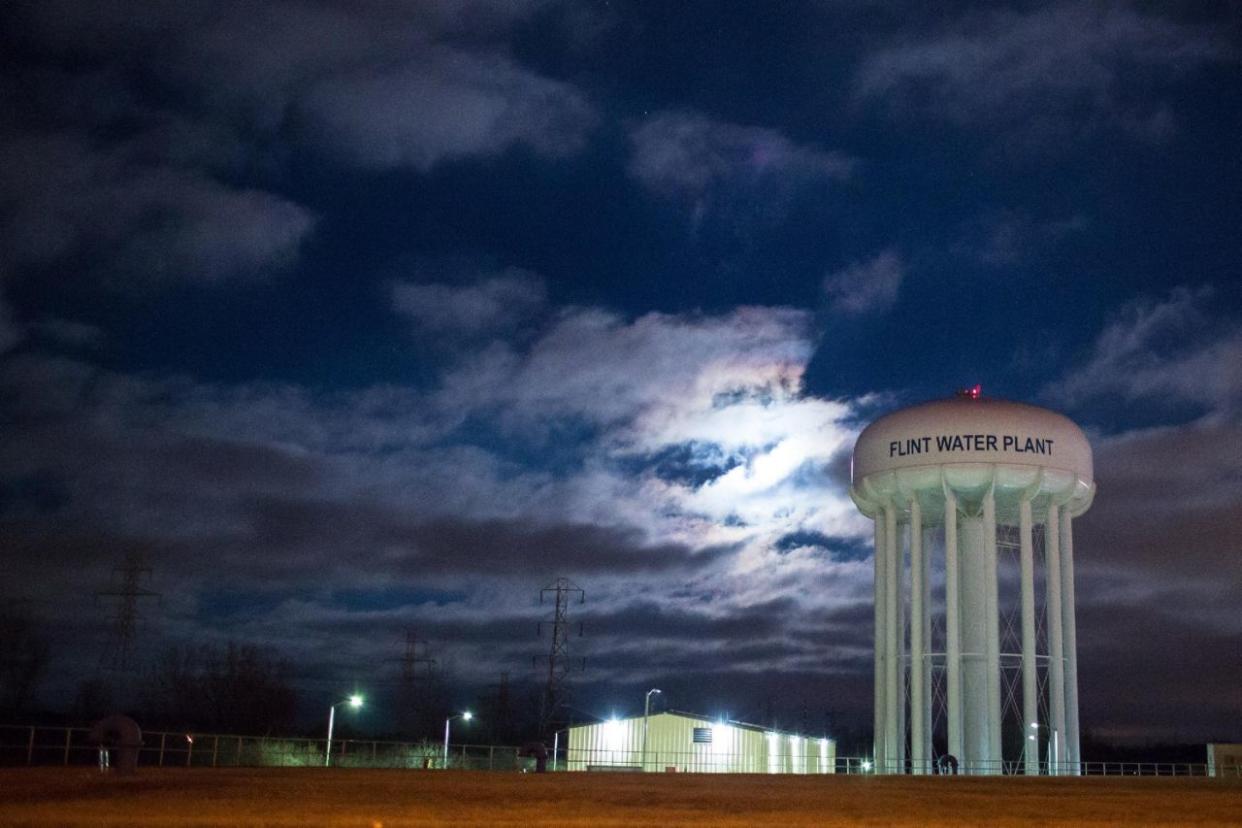 The City of Flint Water Plant is illuminated by moonlight.