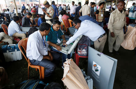 Polling officers check an electronic voting machine (EVM) after collecting it from a distribution centre ahead of the first phase of general elections in Majuli, a large river island in the Brahmaputra river, in the northeastern Indian state of Assam, India April 10, 2019. REUTERS/Adnan Abidi