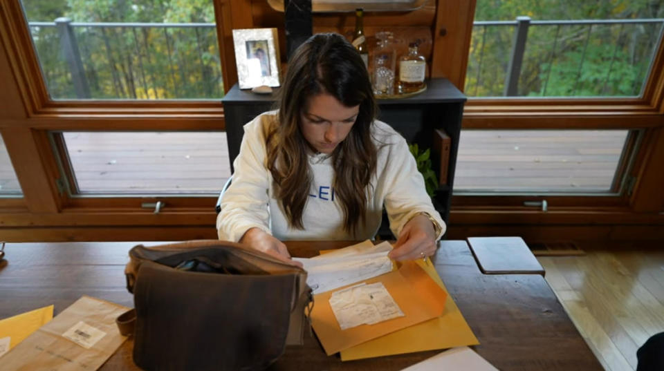 Kelly Gowe looks through documents left behind by her mother, Laura Kowal. / Credit: CBS News