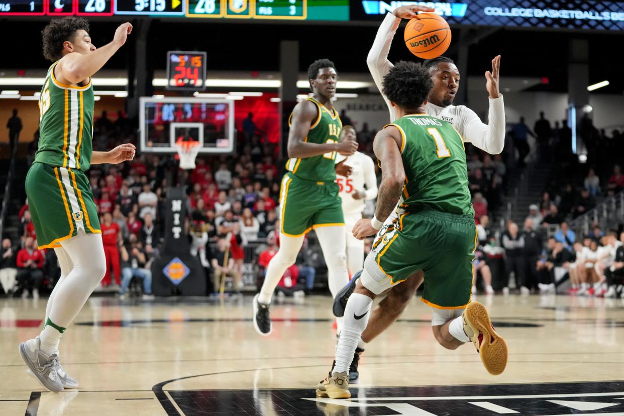 Cincinnati Bearcats guard Day Day Thomas (1) dribbles around San Francisco Dons guard Malik Thomas (1) . Thomas limped off the court at the end of UC's 73-72 overtime win.