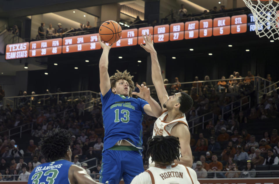 Texas A&M Corpus Christi center Shilo Jackson (13) goes up to shoot against Texas forward Dylan Disu, top right, during the second half of an NCAA college basketball game, Friday, Dec. 22, 2023, in Austin, Texas. (AP Photo/Michael Thomas)