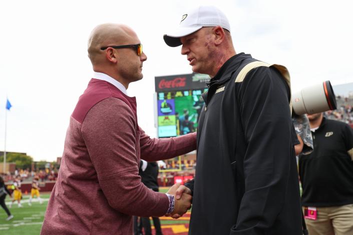 Oct 1, 2022; Minneapolis, Minnesota, USA; Minnesota Golden Gophers head coach P.J. Fleck , left, and Purdue Boilermakers head coach Jeff Brohm shake hands after the game at Huntington Bank Stadium.