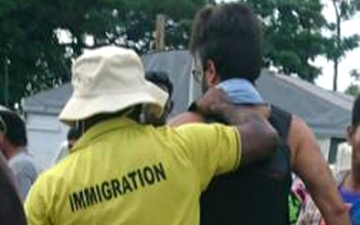 An asylum-seeker (R) is apparently forcibly removed from the Manus Island regional refugee processing centre - AFP