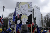 FILE - In this Jan. 8, 2020 file photo remain in the European Union, anti-Brexit protesters, including one with a placard depicting British Prime Minister Boris Johnson under the thumb of U.S. President Donald Trump, demonstrate outside the Houses of Parliament in London, on the day of Prime Minister's Questions taking place inside. (AP Photo/Matt Dunham, File)