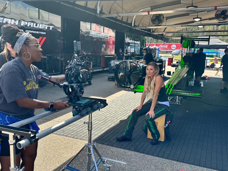 NHRA Top Fuel driver Leah Pruett, right, films a promotional video on the first day of the 54th Amalie Motor Oil NHRA Gatornationals on Thursday at Gainesville Raceway.