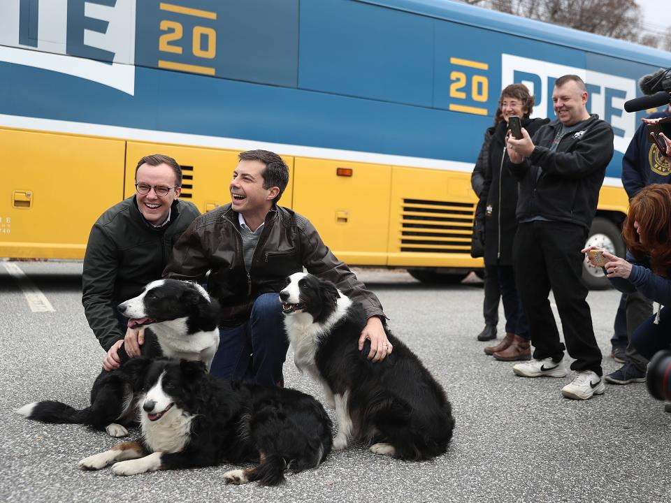 chasten and pete buttgieg petting two dogs on campaign trail