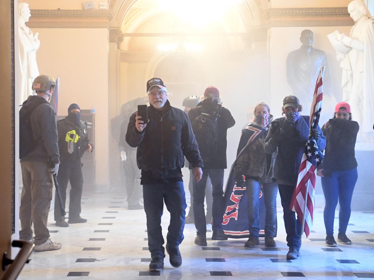 Supporters of then-President Donald Trump enter the Capitol as tear gas fills the corridor on January 6, 2021, in Washington, DC.