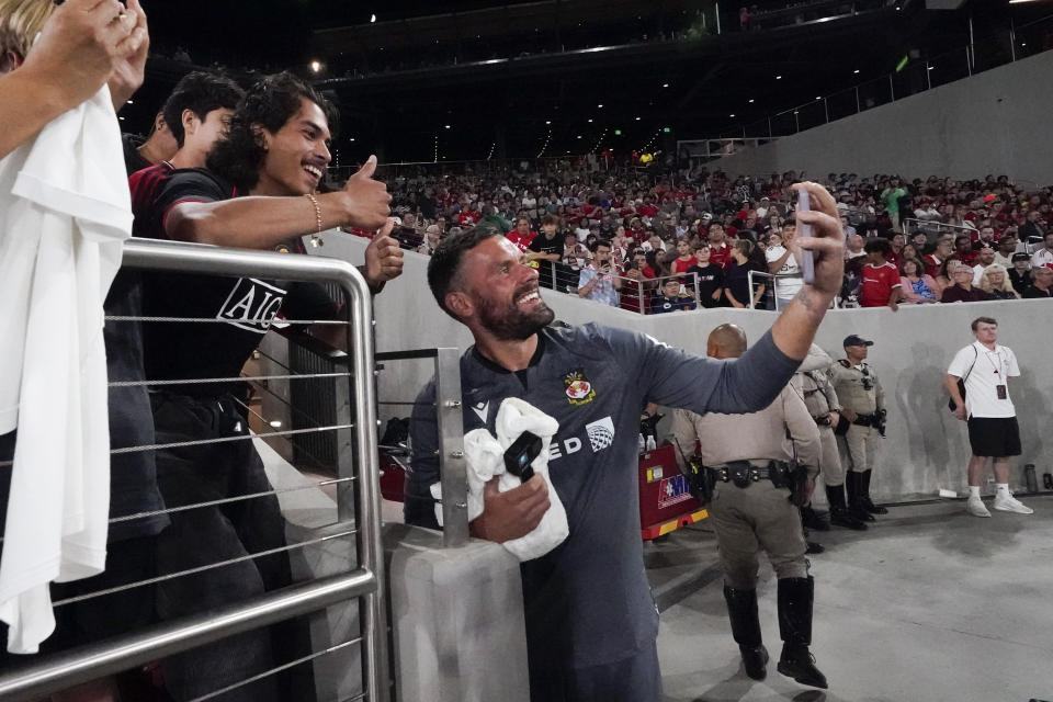 Wrexham goalkeeper Ben Foster poses for a photo with fans during the second half of a club friendly soccer match against Manchester United, Tuesday, July 25, 2023, in San Diego. (AP Photo/Gregory Bull)