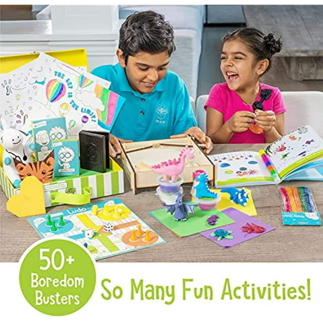 Two children engaged in creative play with various craft supplies and educational games spread out on a table