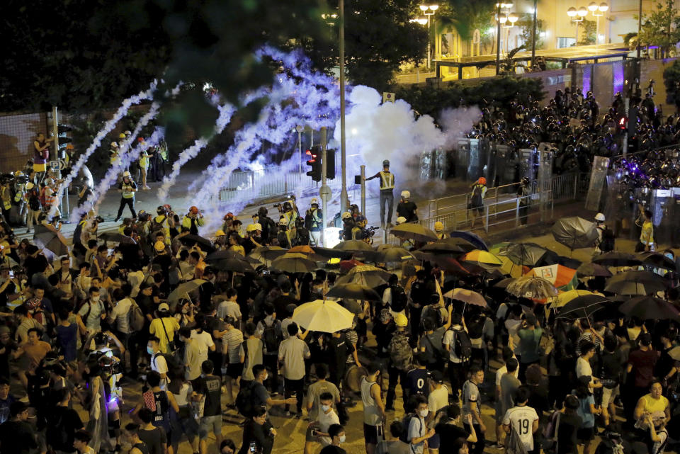 Police fire tear gas into a crowd in Wong Tai Sin district in Hong Kong on Saturday, Aug. 3, 2019. Protesters and authorities clashed in Hong Kong again on Saturday, as demonstrators removed a Chinese national flag from its pole and flung it into the city's iconic Victoria Harbour and police fired tear gas after some protesters vandalized a police station. (AP Photo/Kin Cheung)