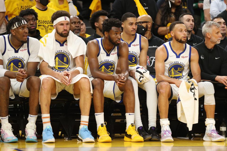 From left, Kevon Looney, Klay Thompson, Andrew Wiggins, Jordan Poole and Stephen Curry of the Golden State Warriors look on from the bench during the fourth quarter against the Boston Celtics in Game 1 of the 2022 NBA Finals at Chase Center.