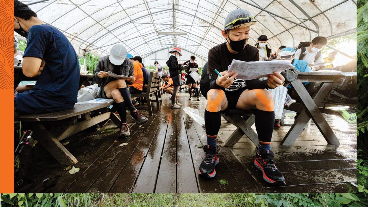 athletes studying maps before 29 mile run on first day