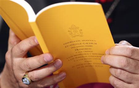 The document of the Evangelii Gaudium (The Joy of the Gospel) from Pope Francis is seen as Bishop Carlo Maria Celli reads during a presentation in Vatican November 26, 2013. REUTERS/Alessandro Bianchi