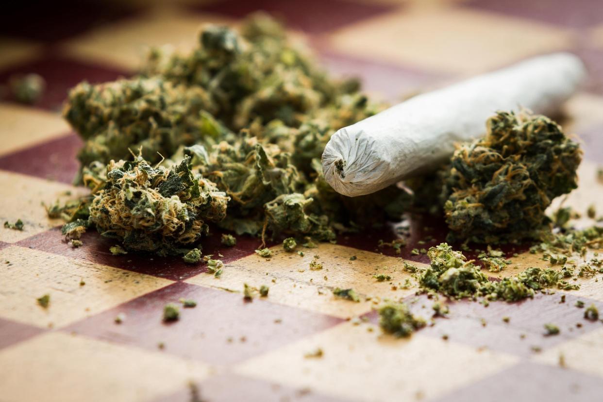 closeup of marijuana joint and buds on a checkerboard table