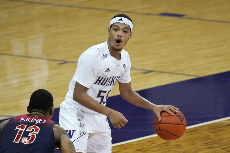 Washington's Quade Green works the ball against Arizona's James Akinjo (13) during the first half of an NCAA college basketball game Thursday, Dec. 31, 2020, in Seattle. (AP Photo/Elaine Thompson)