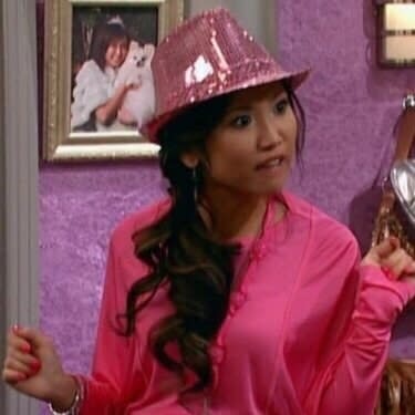 close up of London in a glittery fedora and pink top