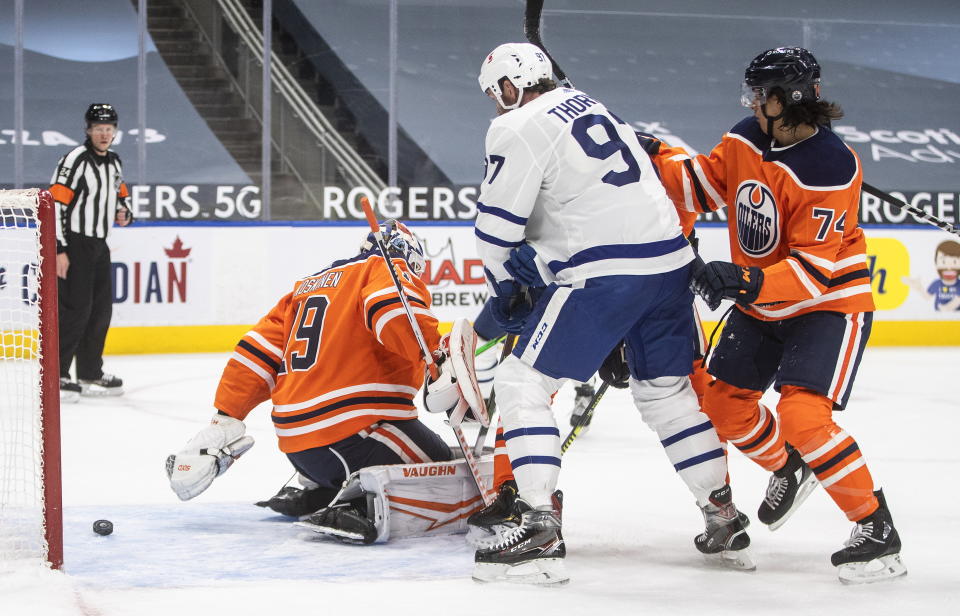Edmonton Oilers goalie Mikko Koskinen (19) is scored on as Toronto Maple Leafs Joe Thornton (97) and Ethan Bear (74) battle in front during first-period NHL hockey game action in Edmonton, Alberta, Monday, March 1, 2021. (Jason Franson/The Canadian Press via AP)