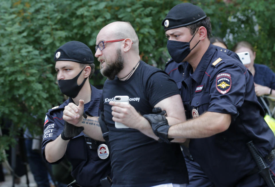 Police officers detain Alexander Chernykh, Kommersant newspaper journalist, during a rally to support Ivan Safronov near the Lefortovo prison in Moscow, Russia, Monday, July 13, 2020. Safronov, an ex-journalist who worked as an adviser to the director of Russia's state space corporation has been arrested and jailed on charges of passing military secrets to Czech intelligence. Ivan Safronov wrote about military and security issues before becoming an adviser to the head of Roscosmos. (AP Photo/Alexander Zemlianichenko)