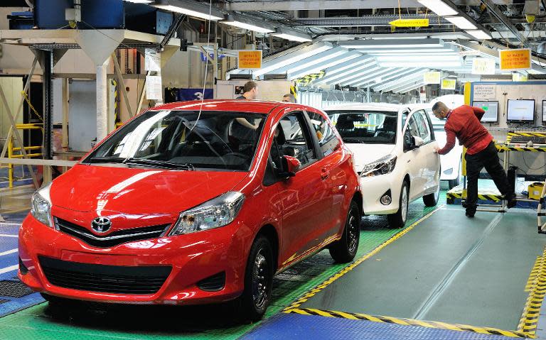 Employees check Toyota Yaris cars on assembly line at a plant of the Japanese carmaker in northern France, on May 16, 2013