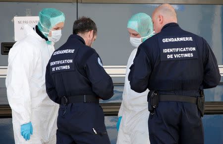 French investigators talk together outside a Gendarmerie mobile forensic van in Seynes-les-Alpes near the crash site of a Germanwings Airbus A320, in French Alps March 27, 2015. REUTERS/Eric Gaillard