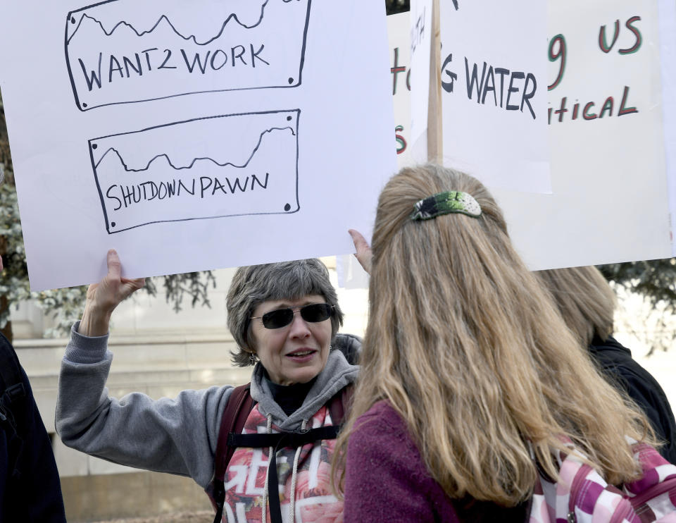 Furloughed worker Peggy Livingston protests the partial government shutdown in downtown Denver on Thursday, Jan. 10, 2019. Livingston helps enforce the Safe Drinking Water Act and the Clean Water Act for the Environmental Protection Agency. (AP Photo/Thomas Peipert)