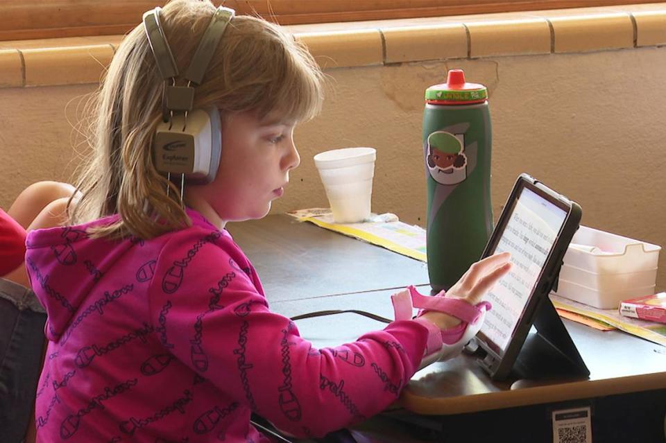 Third grader Grace Epler, an advanced reader who is prone to finishing assignments early, reads on her iPad at Highland Elementary School in Columbus, Kansas, in April. She sometimes spends her free time making up math problems, helping her classmates or playing educational games. Schools across the country saw gaps widen between struggling and high-achieving readers during the pandemic.