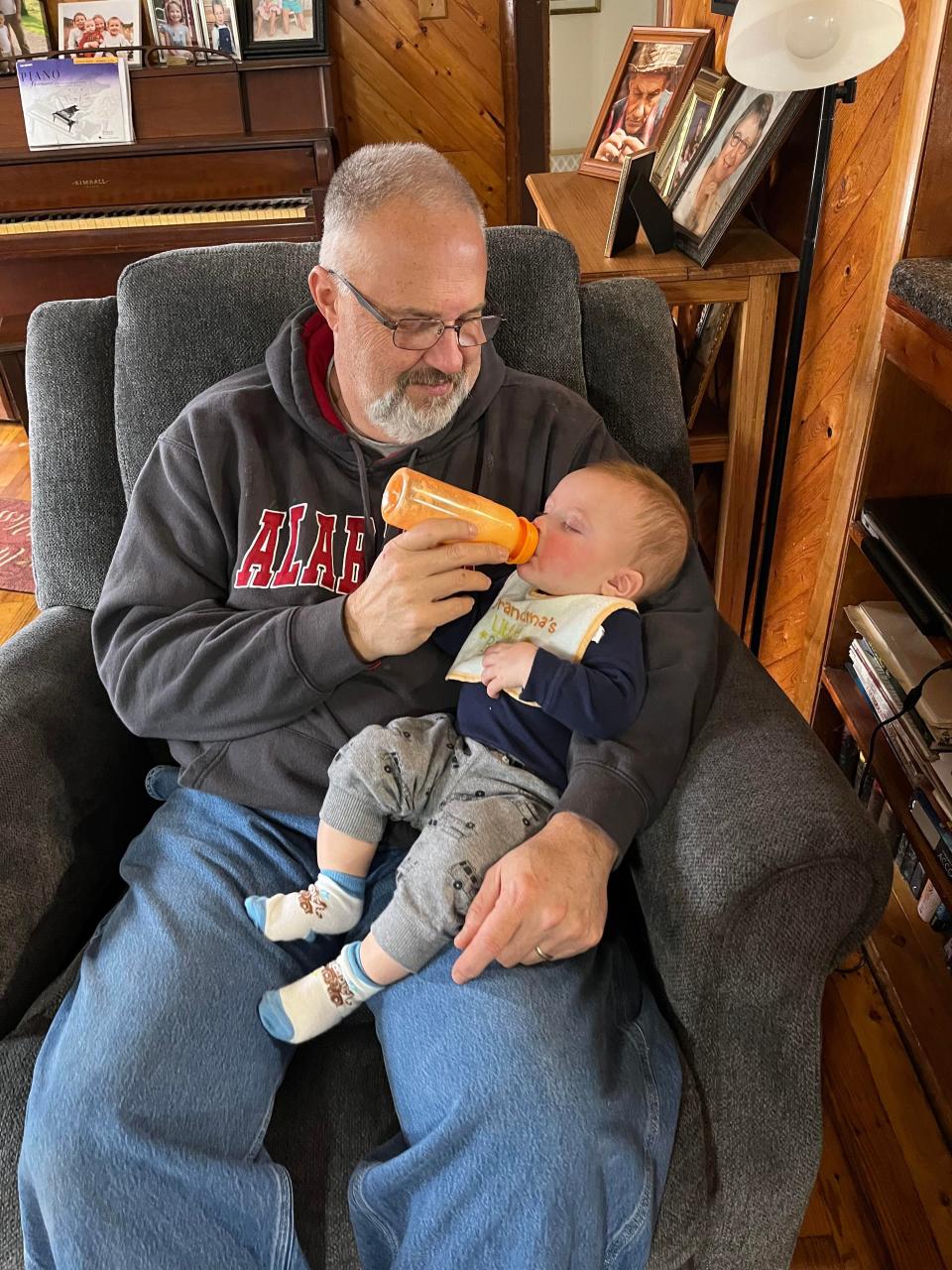 A big fan of Duke basketball and Alabam football, Robinson dons his Crimson Tide sweatshirt while spending time with his youngest of four grandchildren, son Alex's 7-month-old Titus.