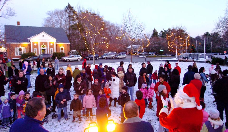 Standing on Norwell’s town common, Santa is surrounded by people who turned out for the holiday tree lighting.