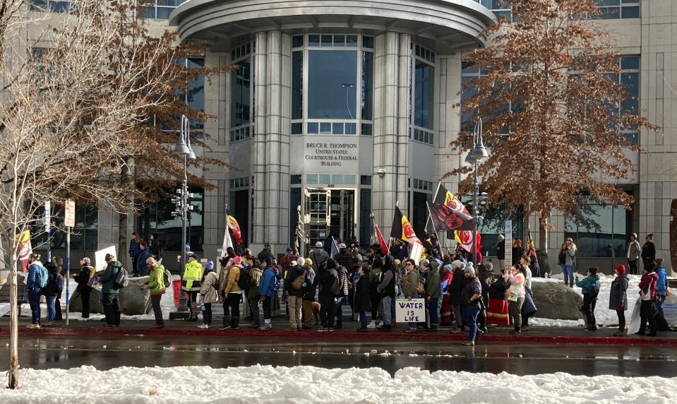 FILE - Dozens of tribe members and other protesters beating drums and waving signs rally in front of the federal courthouse in Reno, Nev. Thursday, Jan. 5, 2023, as a court hearing began over a lawsuit seeking to block a huge lithium mine planned near the Nevada-Oregon line about 200 miles north of Reno. Conservationists are seeking an emergency court order to block construction of a lithium mine near the Nevada-Oregon line. The new request filed Tuesday, Feb. 21, 2023, in federal court in Reno comes after a judge there directed the U.S. Bureau of Land Management to revisit part of its approval of the plans but allowed construction to go forward in the meantime. (AP Photo/Scott Sonner, File)