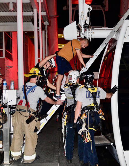Rescue crews help riders safely exit The Wheel at ICON Park Orlando.
