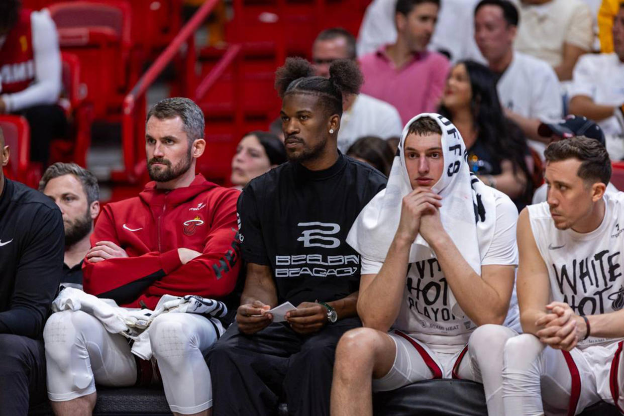 Miami Heat forward Jimmy Butler looks on from the bench between Miami Heat forward Kevin Love (42) and forward Nikola Jovic (5) during the second half of Game 3 of their first-round playoff series at Kaseya Center in Miami on Saturday, April 27, 2024. (D.A. Varela/Miami Herald/Tribune News Service via Getty Images)