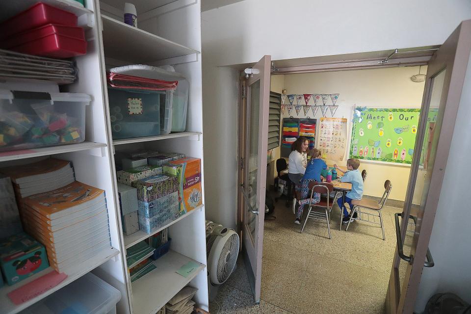 Nikki Budner tutors second graders Elliana Hayes and Zane Kolek in a hallway packed with overflow storage at Whittier Elementary. The district's aging elementary schools have space issues, are not energy efficient, and are not equipped to handle growing technology, officials say.