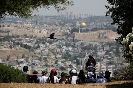 A crow flies past as Jewish school children gather at a look-out point on the Armon Hanatziv Promenade in Jerusalem May 11, 2017. Picture taken May 11, 2017. REUTERS/Amir Cohen