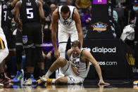 Utah Jazz center Rudy Gobert, standing, checks on Bojan Bogdanovic, who had collided with Sacramento Kings guard Tyrese Haliburton during the first quarter of an NBA basketball game in Sacramento, Calif., Friday, Oct. 22, 2021. (AP Photo/Jose Luis Villegas)