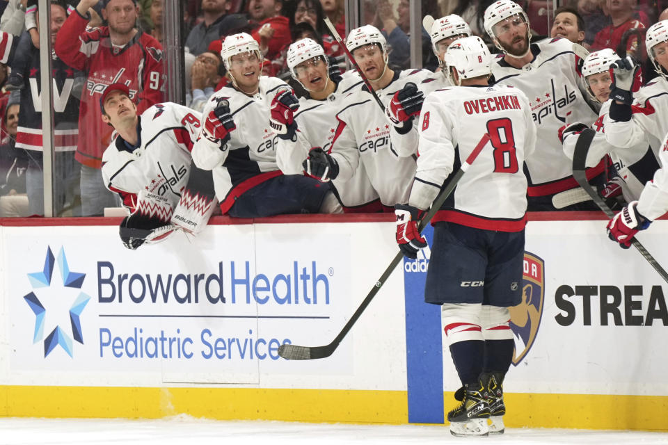 Washington Capitals left wing Alex Ovechkin (8) is congratulated by teammates after scoring a power-play goal against the Florida Panthers during the first period of an NHL hockey game Thursday, Feb. 8, 2024, in Sunrise, Fla. (AP Photo/Jim Rassol)