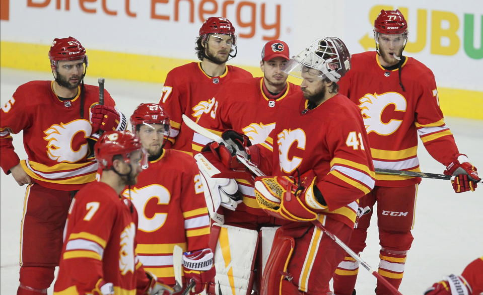 Calgary Flames players stand on the ice after losing 5-1 to the Colorado Avalanche during Game 5 of an NHL hockey first-round playoff series Friday, April 19, 2019, in Calgary, Alberta. (Dave Chidley/The Canadian Press via AP)