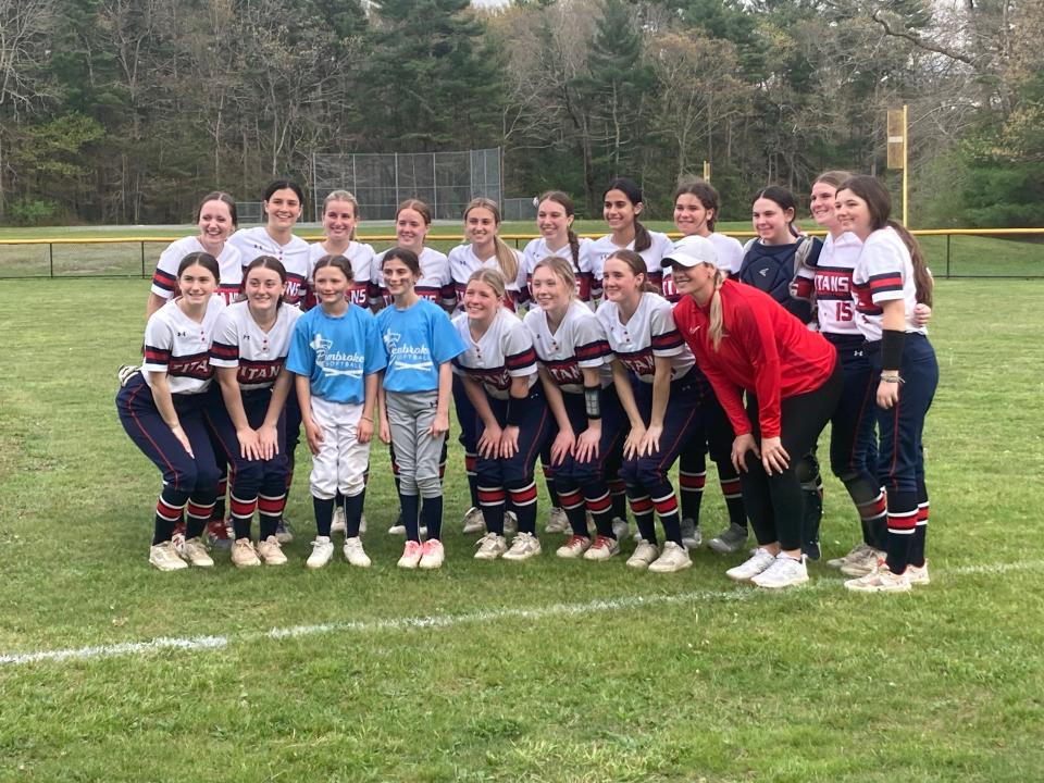 Members of the Pembroke High softball team, including first-year head coach Brittney Noons (in red jacket) pose for a photo after beating Falmouth, 6-0, at home on Monday, May 6, 2024 to clinch a Div. 3 playoff berth.