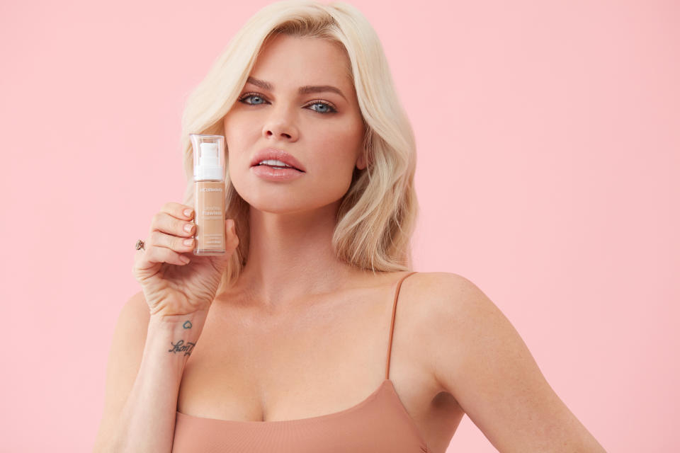 Sophie Monk poses with a bottle of MCoBeauty foundation in a promotional image