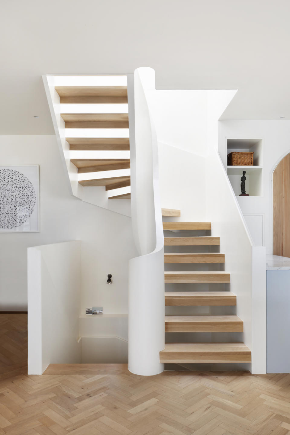 wood stairs with a curved white balustrade in a modern entryway