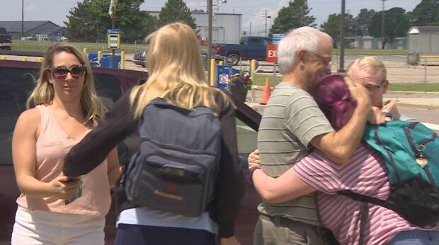 Paige MacLean, right, hugs her family after arriving at the airport on a flight from Toronto on Sunday. (Rick Gibbs/CBC - image credit)