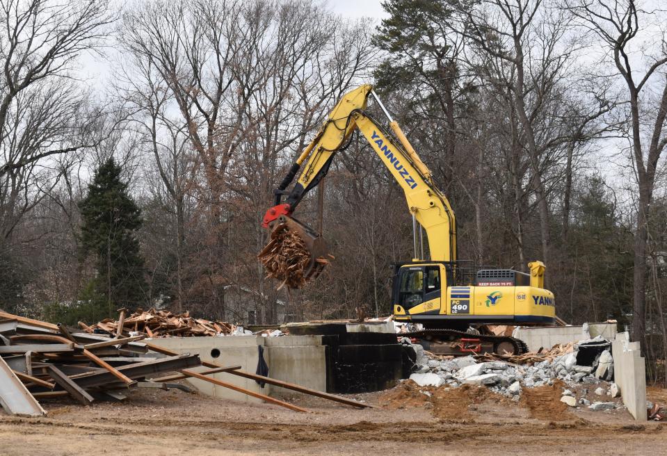 An excavator sorts rubble at the demolition scene on Winding Drive in Cherry Hill.