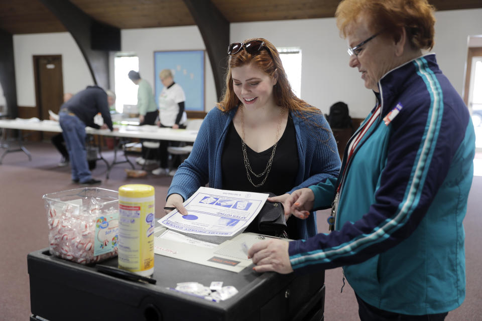 Voter Shelby Zurick Beasley, left, casts her ballot in the Illinois primary with the help of election worker Irene Jester at Parkview Church of the Nazarene Tuesday, March 17, 2020, in Fairview Heights, Ill. Voters are casting ballots in the Illinois primary despite the coronavirus outbreak, with judges at this polling place seeing a slow but steady turnout. (AP Photo/Jeff Roberson)