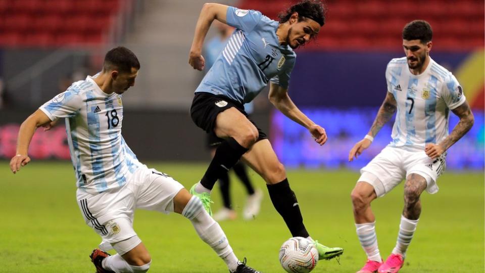 Guido Rodriguez (izqda.) y Rodrigo de Paul (dcha.) intentan detener a Edinson Cavani