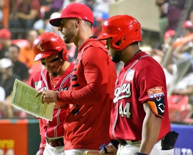 Portsmouth High School graduate Mike Montville goes over the scouting report during a break during a Criollos de Caguas game in the Puerto Rican Winter League. Montville served as the team's hitting coach, under manager Yadier Molina. Montville has been named as the new hitting coach for the Norfolk Tides, the Triple-A affiliate of the Baltimore Orioles.