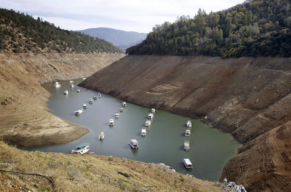 FILE - In this Oct. 30, 2014, file photo, houseboats float in the drought-lowered waters of Oroville Lake near Oroville, Calif. Rainstorms grew more erratic and droughts much longer across most of the U.S. West over the past half-century as climate change warmed the planet, according to a sweeping government study released, Tuesday, April 6, 2021, that concludes the situation in the region is worsening.(AP Photo/Rich Pedroncelli, File)