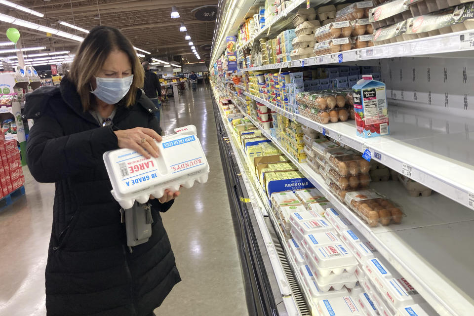 A shopper checks eggs before she purchases at a grocery store in Glenview, Ill., Tuesday, Jan. 10, 2023. Anyone going to buy a dozen eggs these days will have to be ready to pay up because the lingering bird flu outbreak, combined with soaring feed, fuel and labor costs, has led to prices more than doubling over the past year. (AP Photo/Nam Y. Huh)