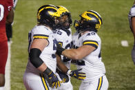 Michigan's Hassan Haskins (25) celebrates with Karsen Barnhart, left, and Ben Mason during the third overtime of an NCAA college football game against Rutgers on Saturday, Nov. 21, 2020, in Piscataway, N.J. Michigan won 48-42. (AP Photo/Frank Franklin II)